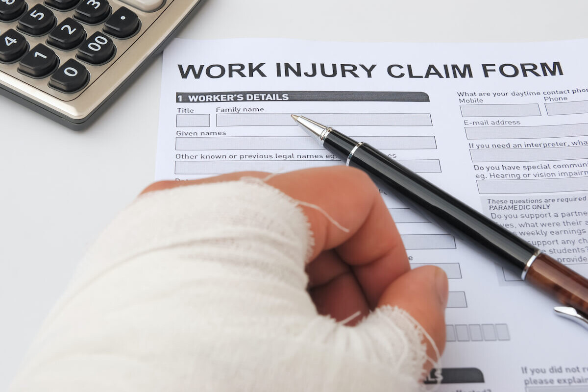 a male with a broken left hand filling out a work injury form