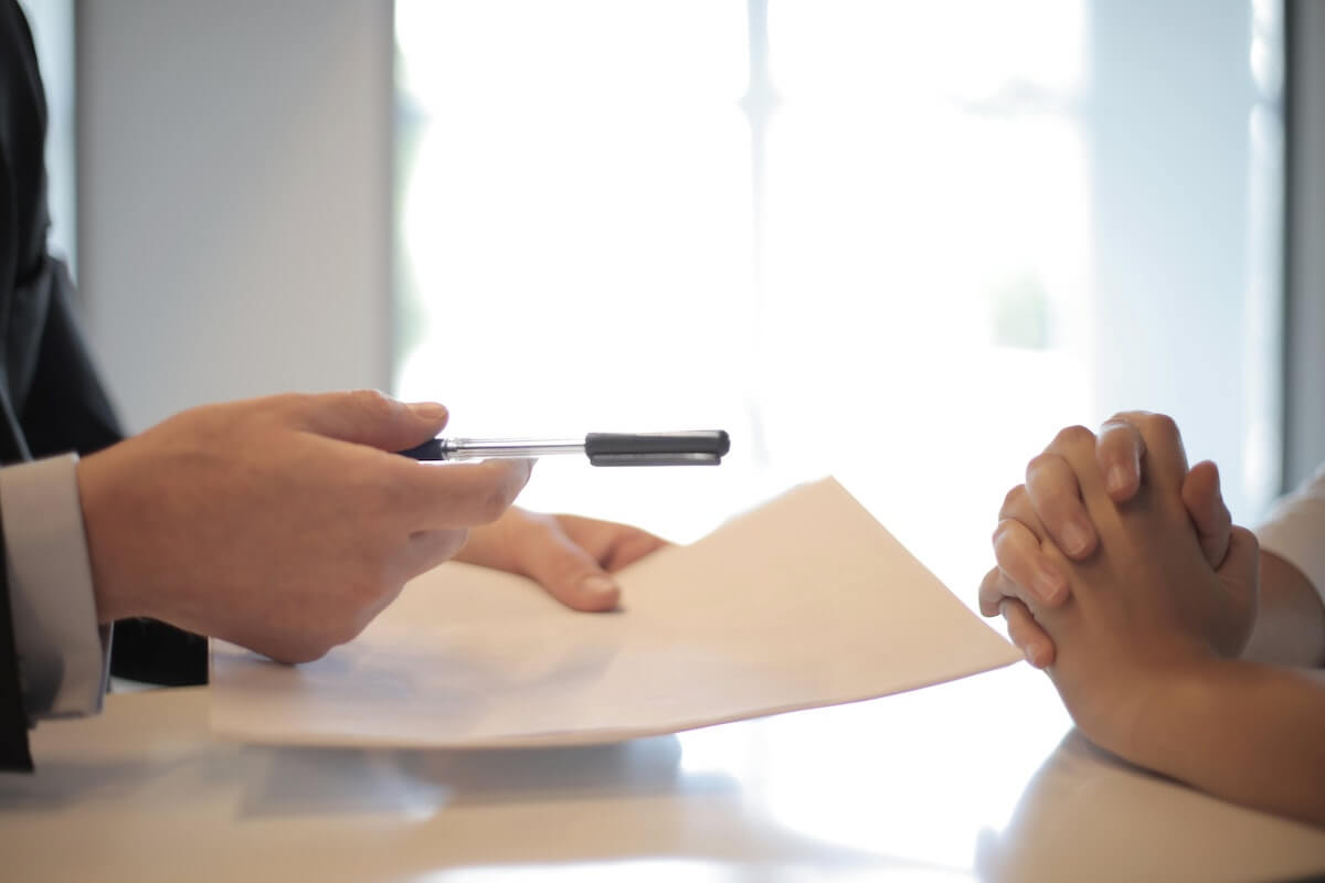 two people making a formal business deal via signing paperwork